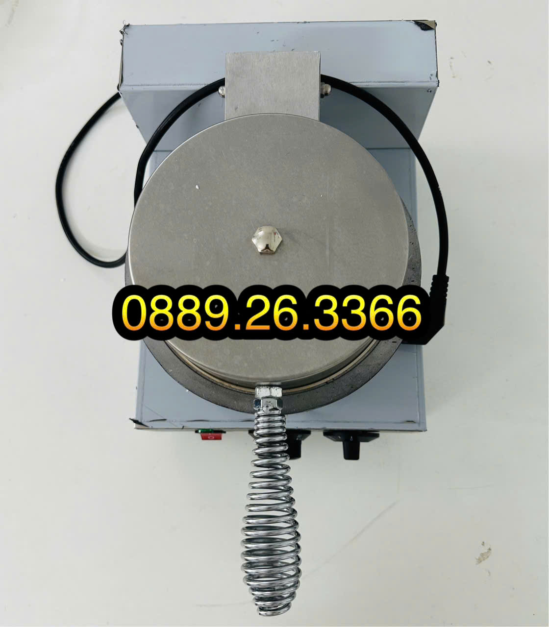 Máy nướng bánh waffle bằng thép không gỉ với tay cầm xoắn ốc và dây điện.