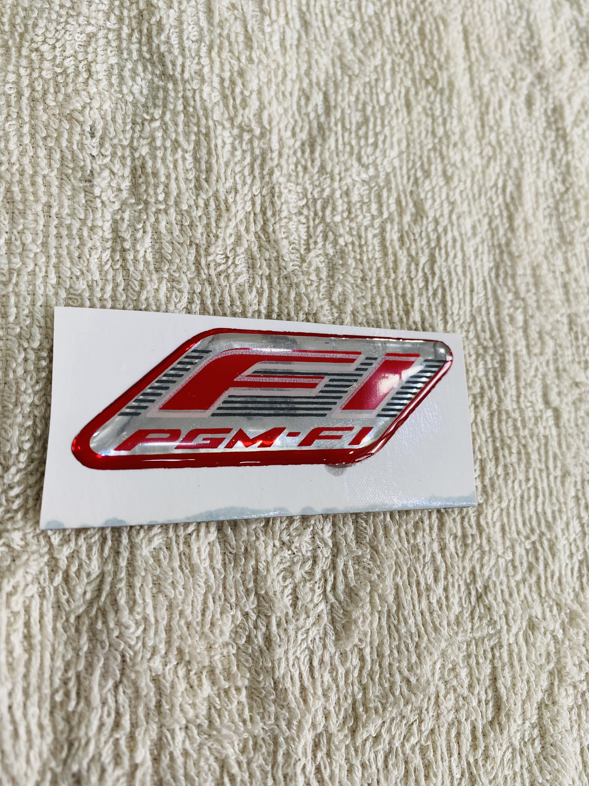 Tem dán xe máy logo Fi PGM nhựa dẻo màu đỏ có sẵn keo siêu dính