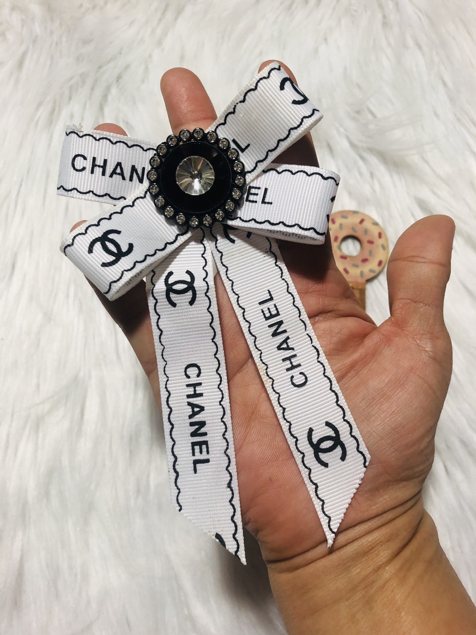 Cài áo nơ trắng viền chữ. kt 8 x 14cm