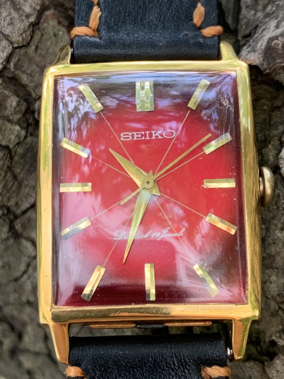 Đồng hồ nam Seiko Diashock cơ cót 19 jewels, mặt chử nhật màu đỏ, niềng lắc kê vàng, dây da của Nhật