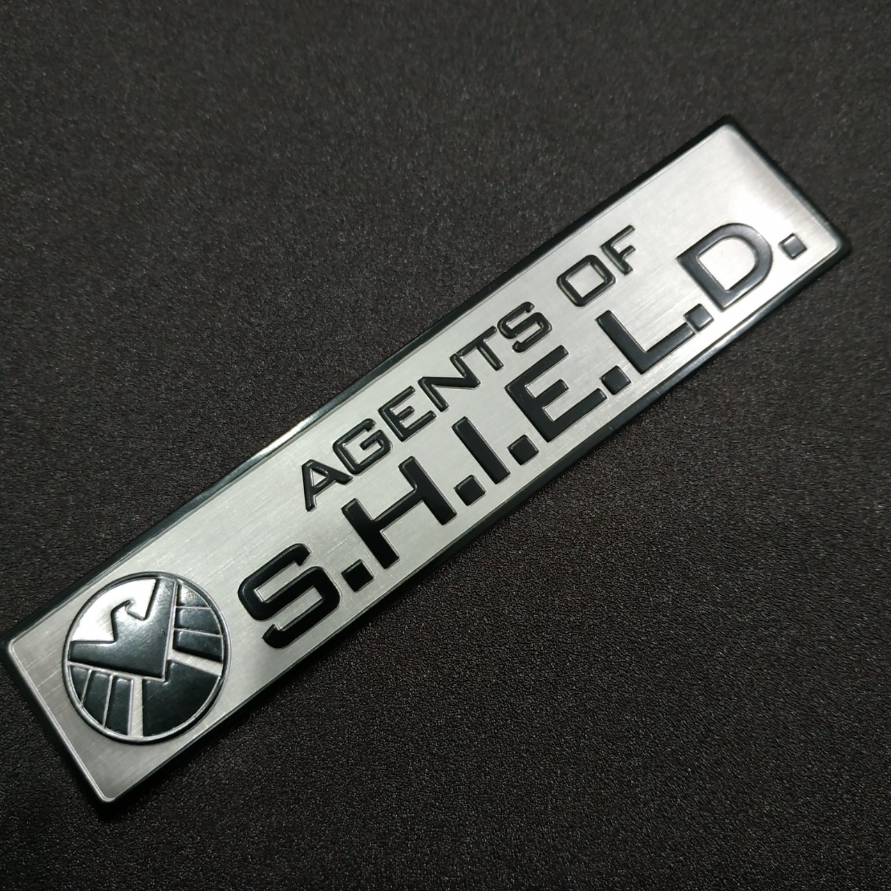Tem nhôm dán xe SHIELD dài 12x2.6cm nền trắng