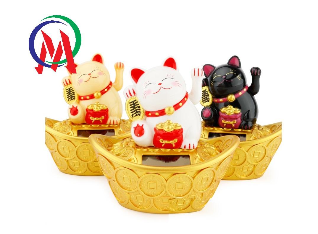 Chú mèo may mắn ngồi trên thỏi vàng