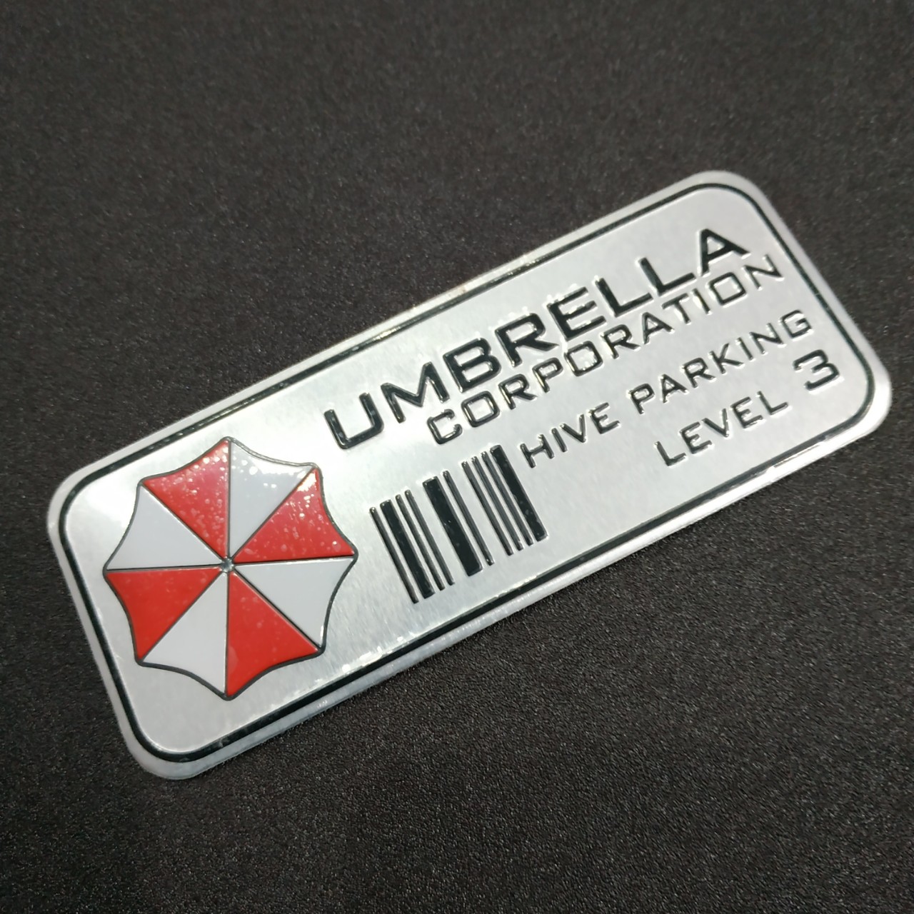 Tem nhôm dán xe Umbrella hive parking lever 3 trắng 11x4.5cm