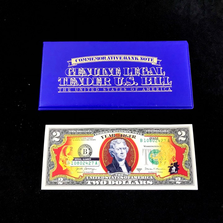 Tiền 2 USD Hình Con Cọp Mạ Vàng 2022; là tờ tiền 2 USD thật 100% được in hình chú Cọp mạ vàng bằng lớp keo vàng phản quang; Kích thước bao da ở ngoài là 16x8cm (Dài x Rộng)- SP005372