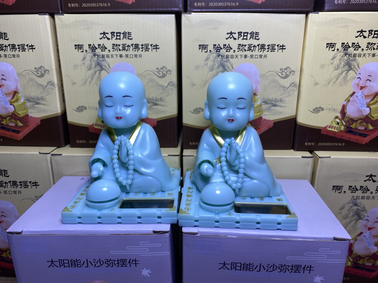 Tượng chú tiểu gật đầu vẫy tay năng lượng mặt trời màu xanh ngọc dạ quang