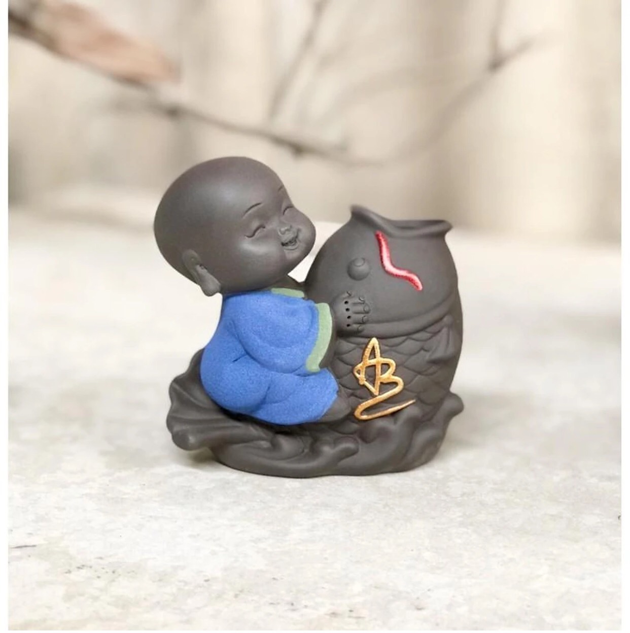 Tượng chú tiểu cưỡi cá chép trồng cây tài lộc chú AN