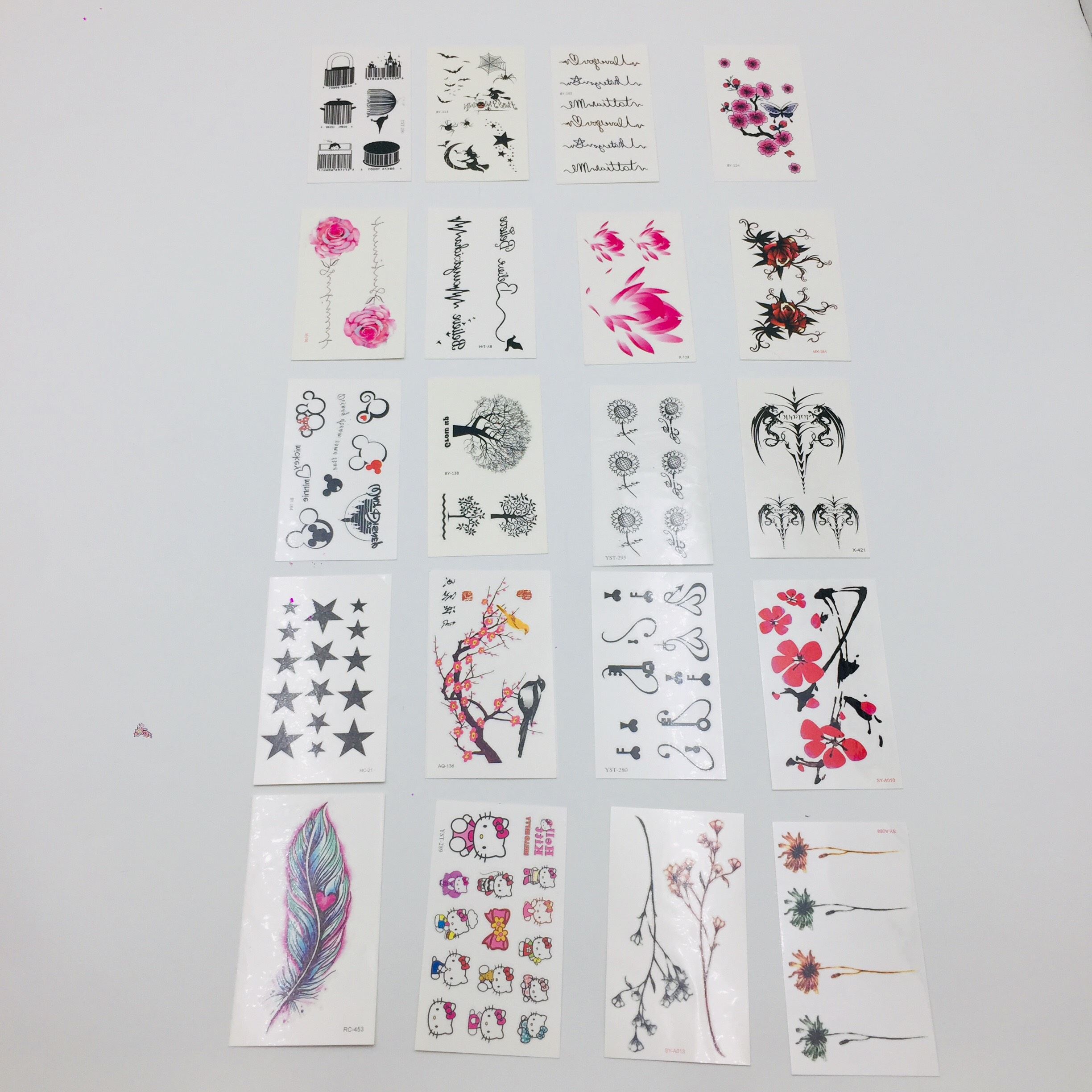 Combo 20 tấm xăm dán mini dán nước gồm mẫu lông vũ xanh hồng, mẫu hoa khô,mẫu cây cổ thụ, hoa hướng dương, ngôi sao, cành đào, chìa khóa, hoa sen, con mèo kitty, chữ, phù thủy,....
