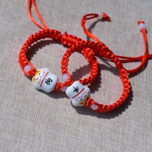 Vòng đan dây rút chỉ đỏ charm mèo gốm Nhật Bản Maneki Neko