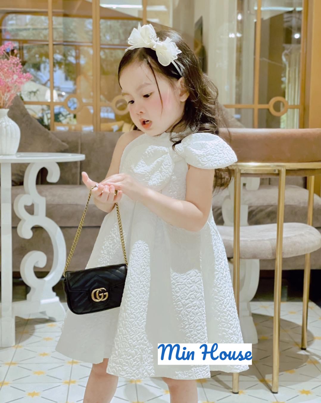 Váy gấm xốp cổ yếm phối nơ lệch cho bé gái diện lễ Tết