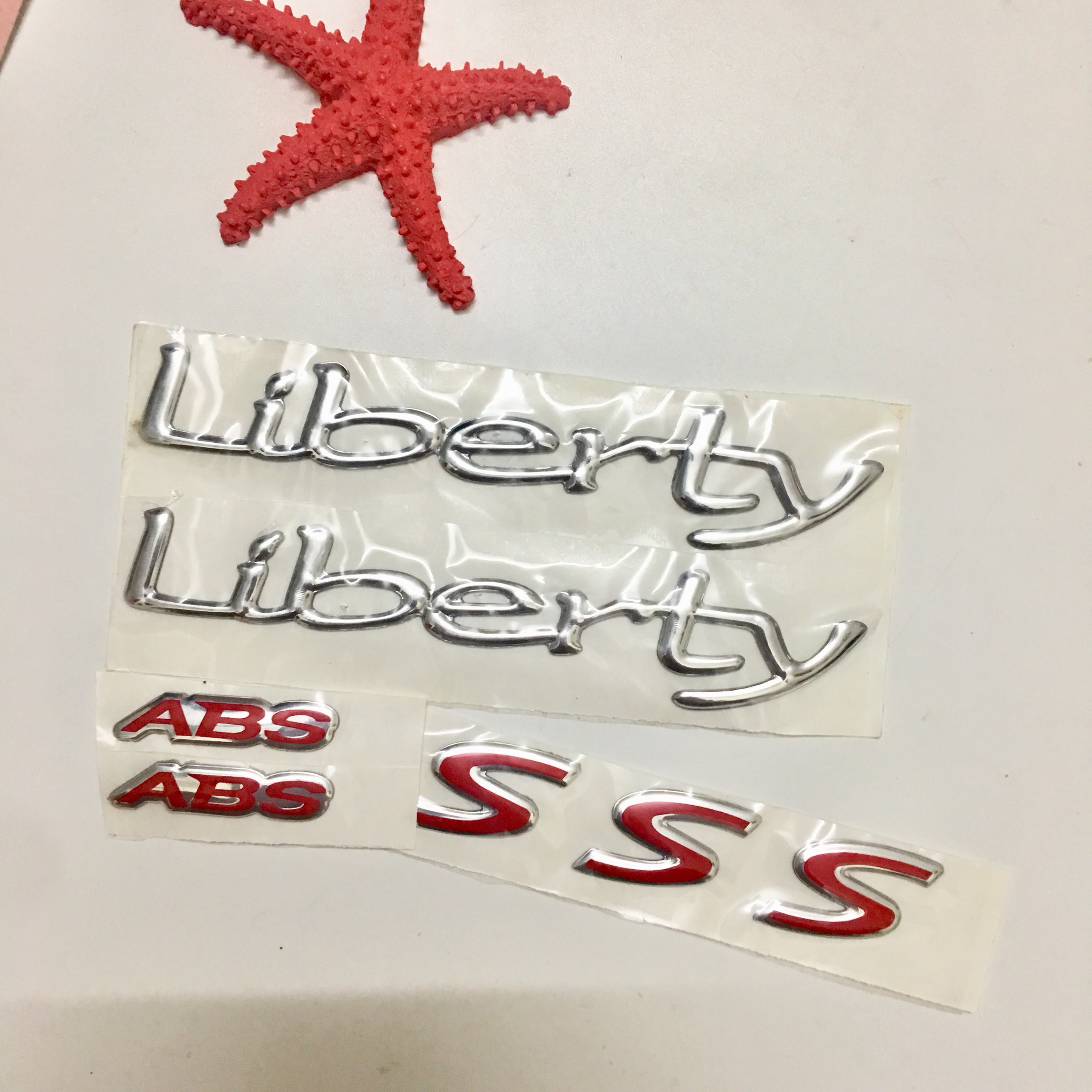 Tem dán xe Liberty ABS, tem chất liệu nhựa dẻo, có keo dán sẵn tiện lợi, cho xe bạn trông như mới
