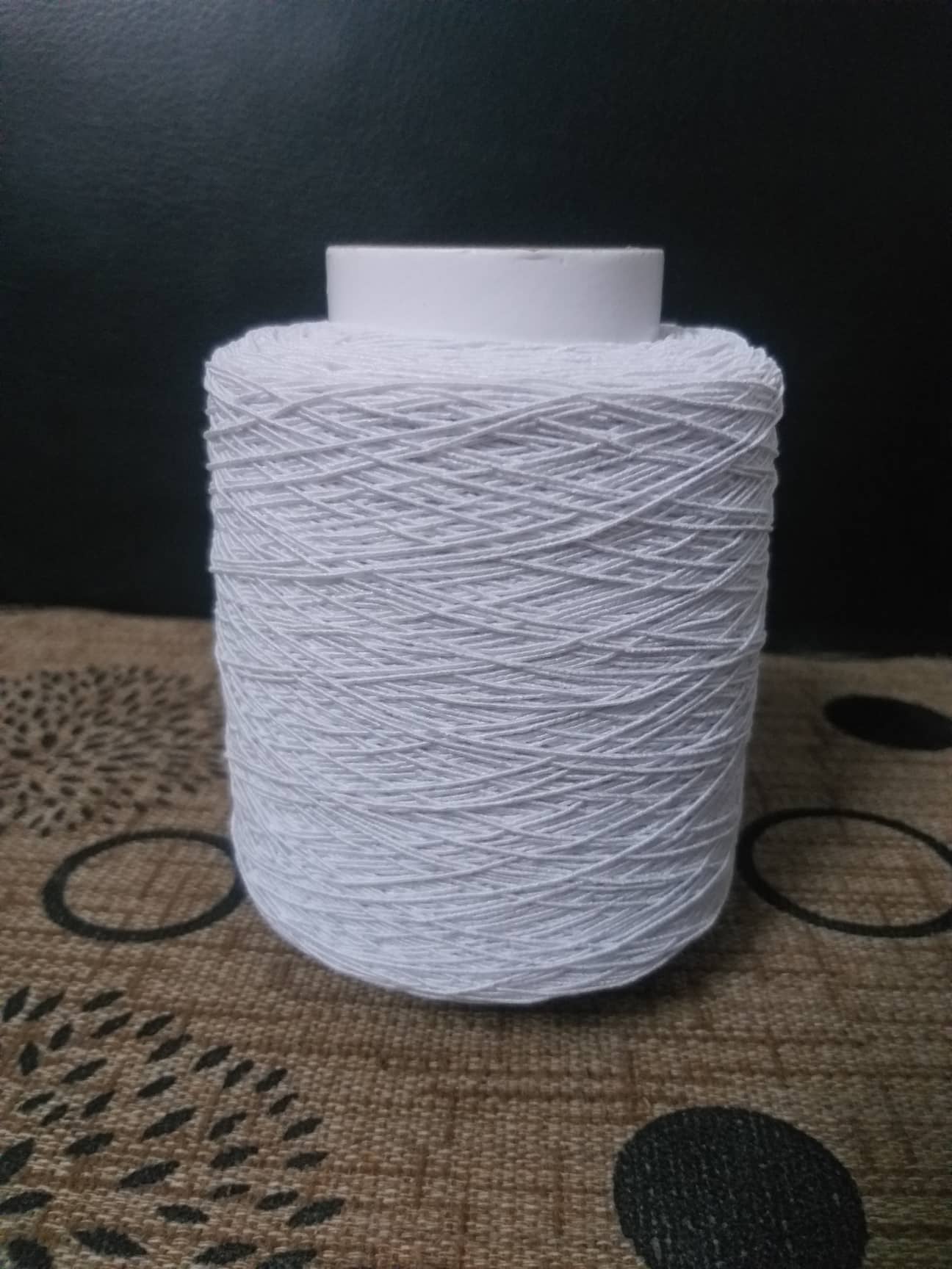 Cuộn chỉ thun may nhún màu Trắng. Sợi thun bọc chỉ loại 63/150 dùng để may bao tay, vớ tất mỏng.