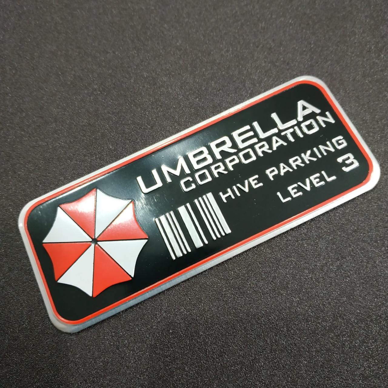 Tem nhôm dán xe Umbrella hive parking lever 3 đen 11x4.5cm