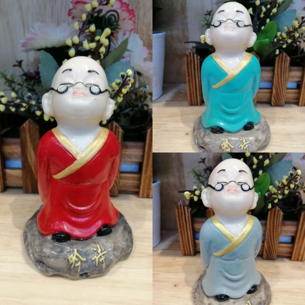 Tượng chú tiểu đeo kính đọc sách