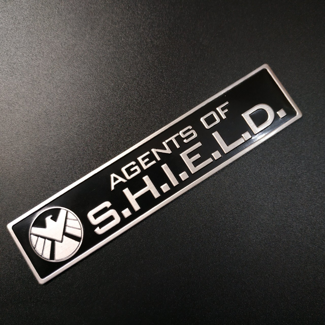 Tem nhôm dán xe SHIELD dài 12x2.6cm nền đen