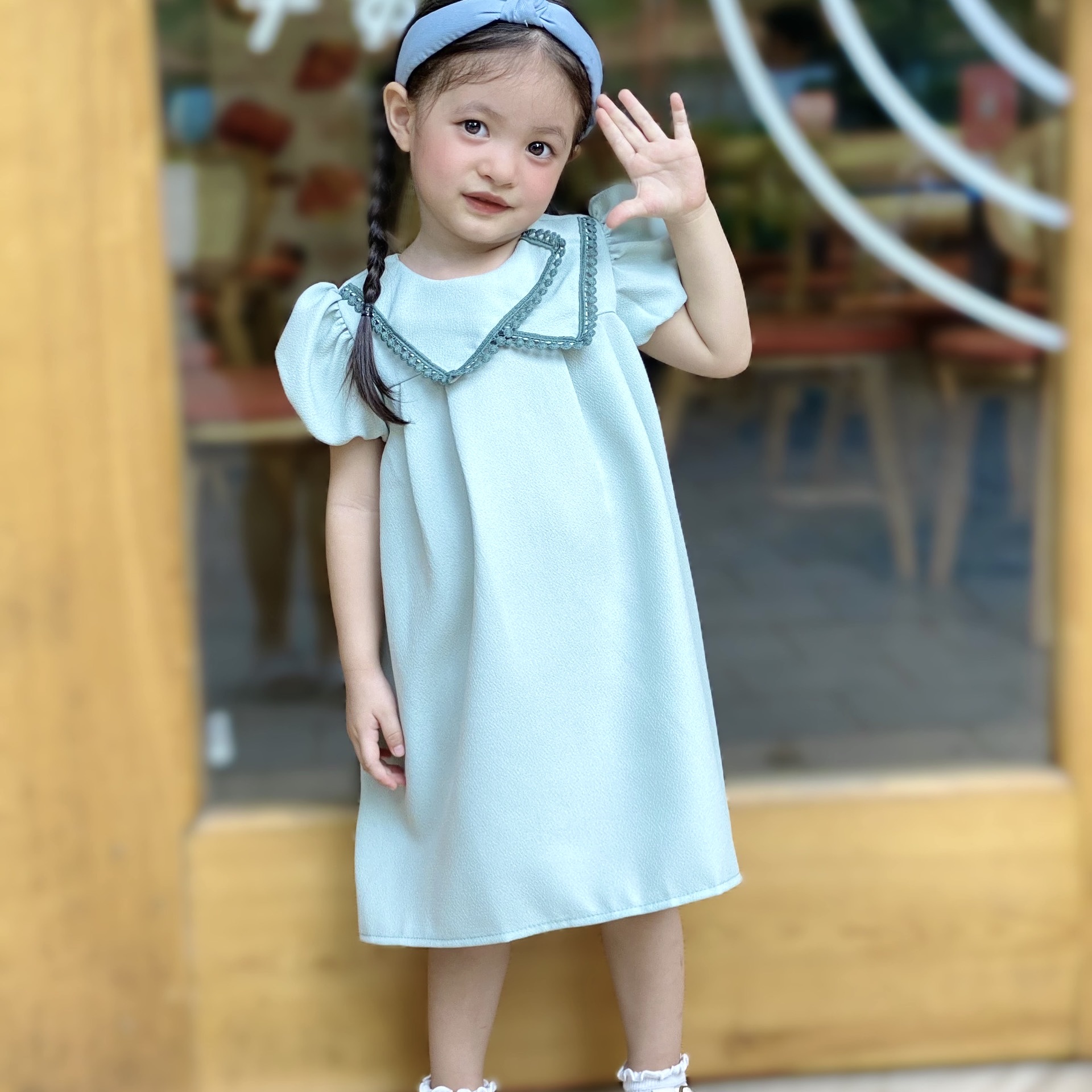 Đầm dáng A cổ tròn thắt nơ trái tim phối hoa nhí
